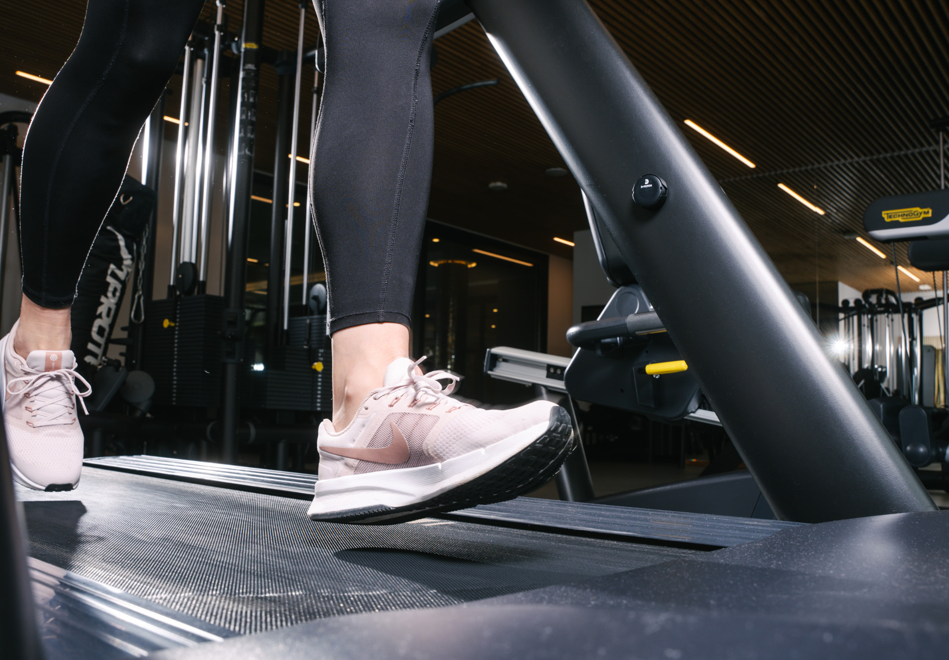 Runner's feet on a treadmill with a D-Fetch sensor fitted to the arm