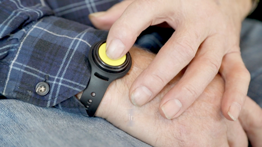 A resident pressing the alarm button on a D-Fetch wristband
